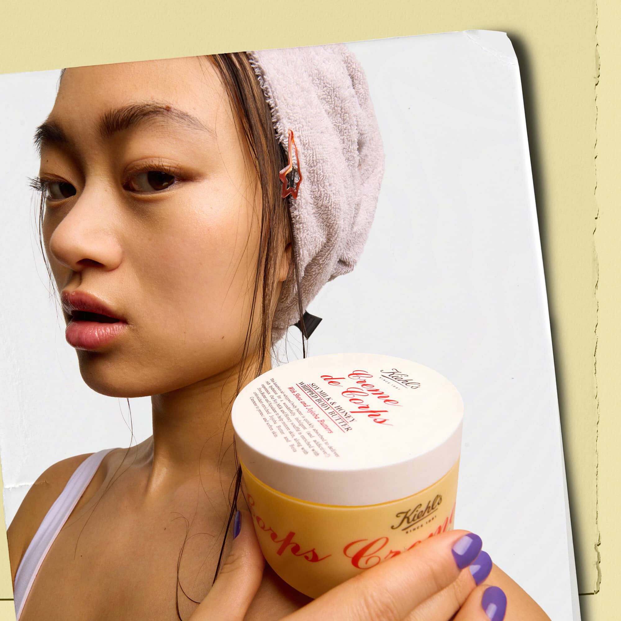 Model drži posodico masla za telo Kiehl's Creme de Corps Whipped Butter