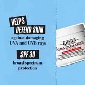 Lonček Ultra Facial Cream SPF 30 na modrem ozadju z besedilom: »Pomaga pri obrambi kože pred škodljivimi UVA in UVB žarki. Zaščita širokega spektra ZF 30.«
