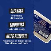 Ultimate Man Body Scrub Soap na temno modrem ozadju z besedilom: »Očisti umazanijo in olje. Učinkovito lušči kožo in pomaga ublažiti hrapavost na trdih predelih, kot so komolci in pete.«