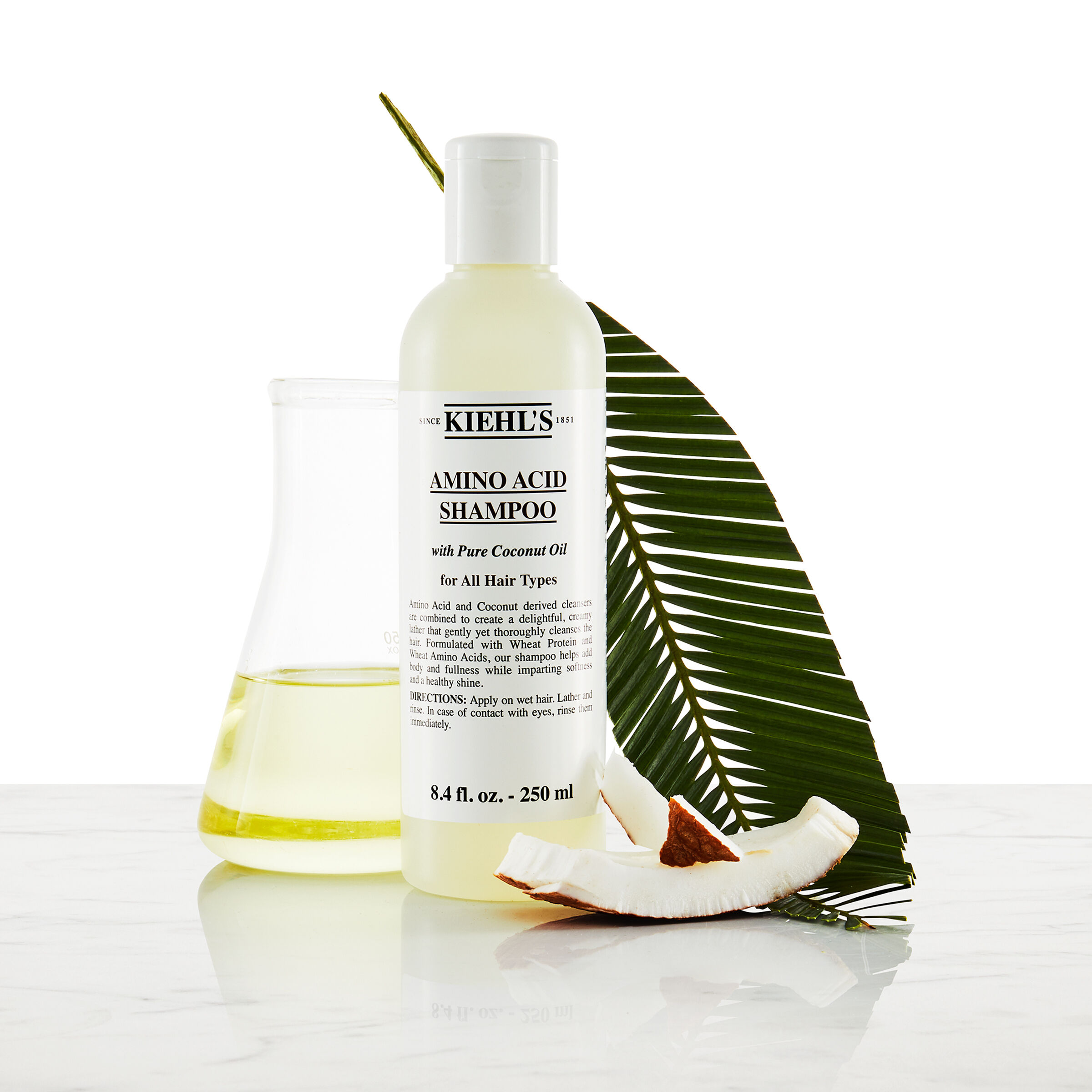 Model z brki in stekleničko šampona Kiehl's Amino Acid Shampoo