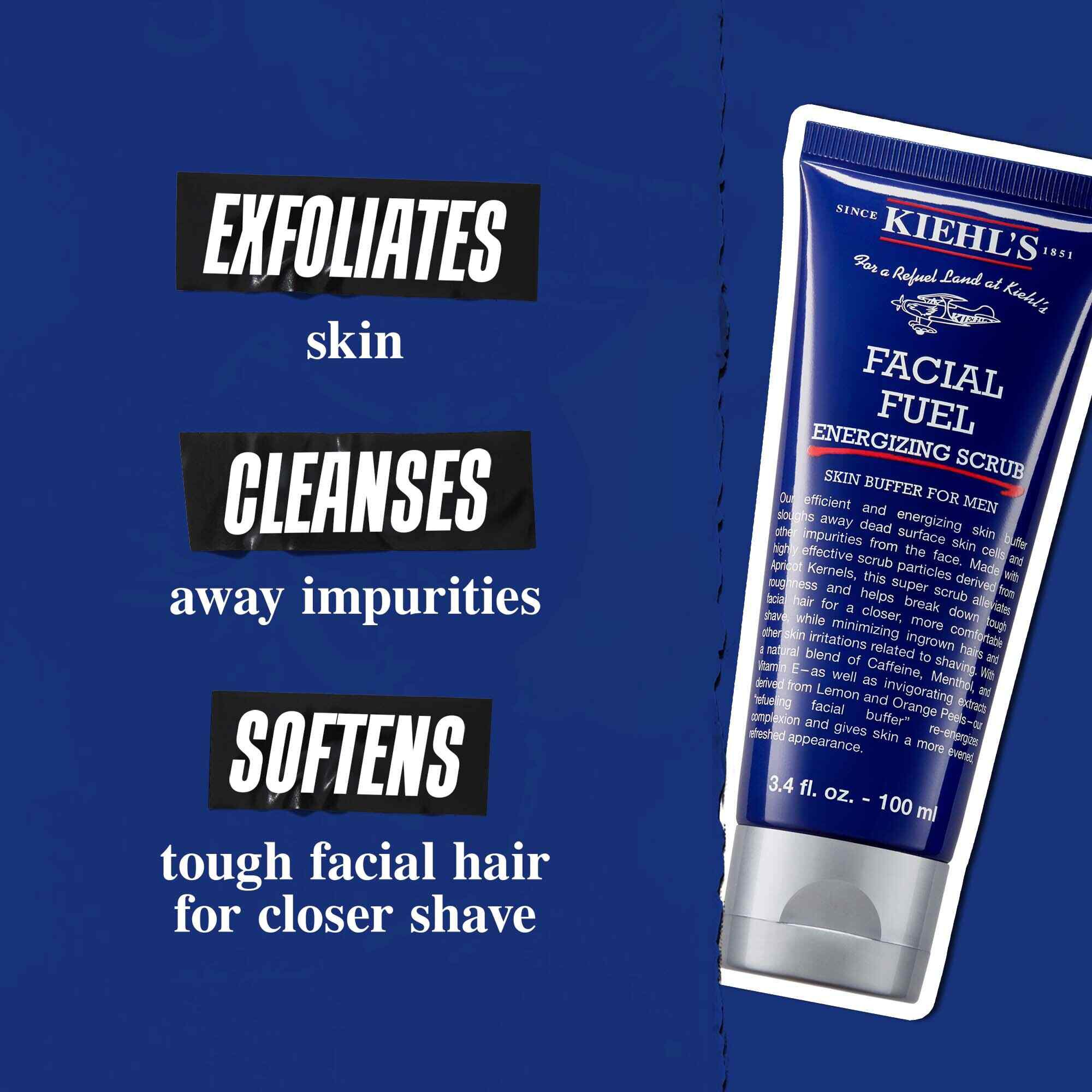 Tuba Facial Fuel Energizing Scrub na temno modrem ozadju. Besedilo se glasi: »Odstrani odmrle celice, očisti nečistoče in zmehča trde dlake na obrazu za tesnejše britje.«
