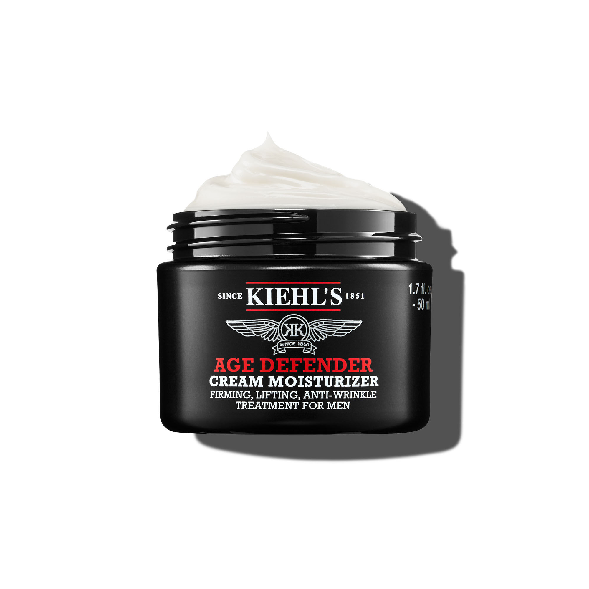 50-mililitrska posodica kreme Kiehl's Age Defender Cream Moisturizer s teksturo stepene smetane na belem ozadju.
