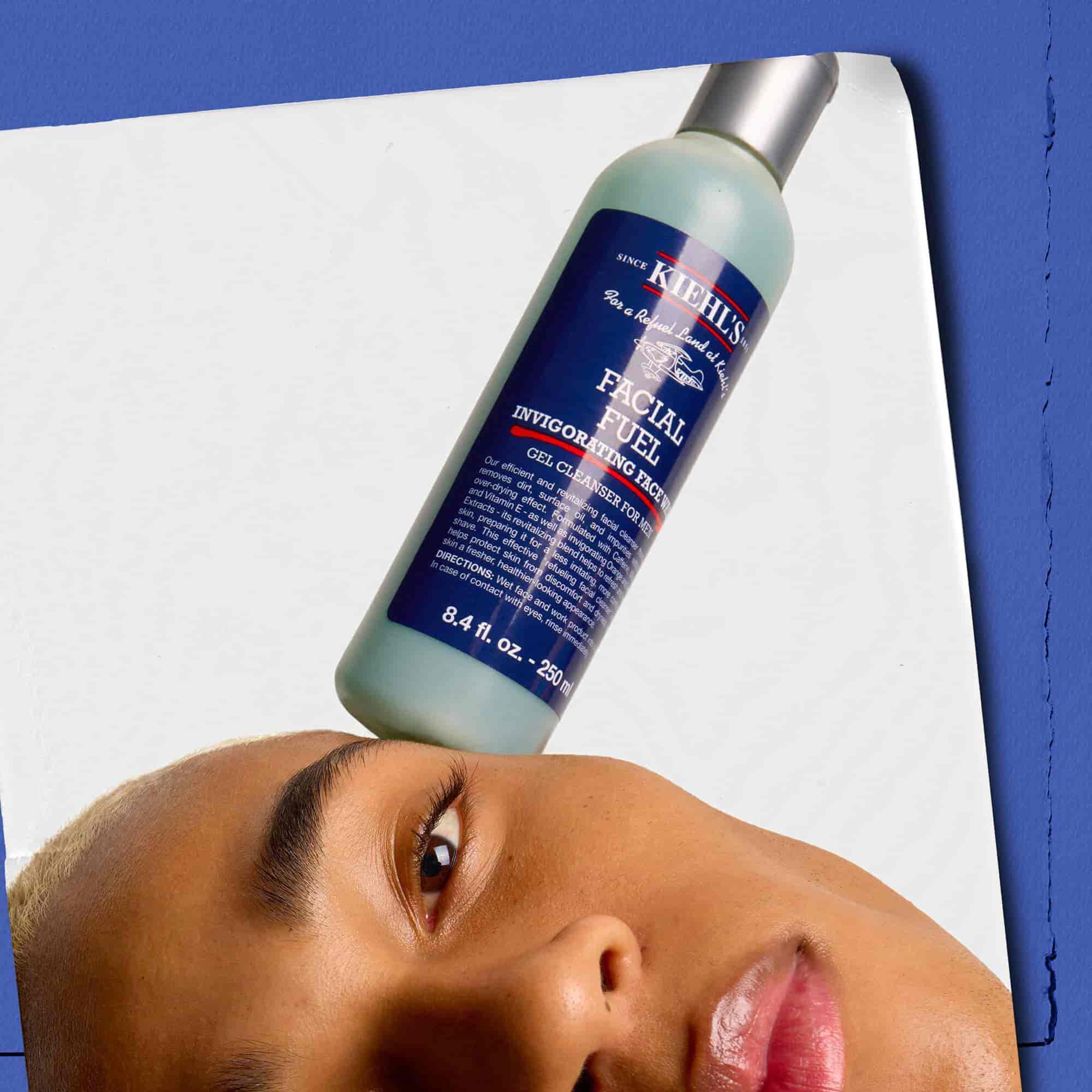 Model s stekleničko energizirajočega gela za čiščenje obraza Kiehl's Facial Fuel, ki jo uravnoteži na obrazu