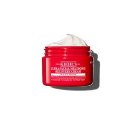 Rdeča posodica kreme Kiehl’s Ultra Facial Meltdown Recovery Cream Whip s teksturo stepene smetane.