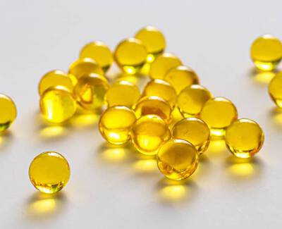 A scattered group of round, translucent yellow beads on a light surface.