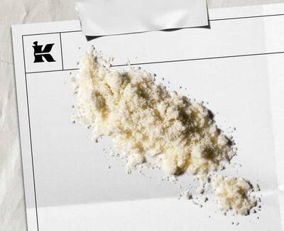 Umazano bel prah, ki predstavlja 1 % koloidne ovsene kaše na beli plošči s črnim logotipom Kiehl's v kotu.