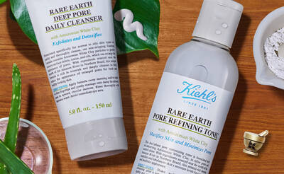 Two skincare products are displayed: a tube of "Rare Earth Deep Pore Daily Cleanser" and a bottle of "Rare Earth Pore Refining Tonic," both featuring ingredients like Amazonian white clay. The background includes natural elements like aloe vera and a small bowl of powder.