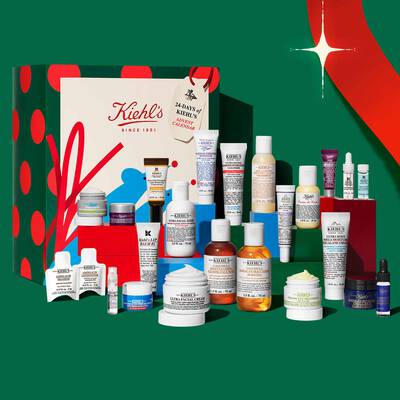 Kiehl's praznični adventni koledar in darilni set za nego kože z različnimi kremami, serumi, čistilnimi sredstvi in tretmaji na svečani predstavitvi.
